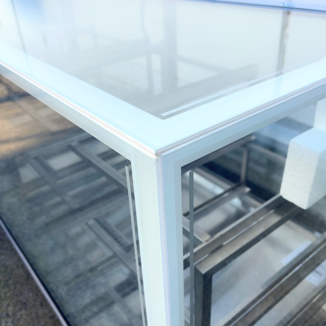 Close-up of a modern glass-top refrigerated cold display cabinet with a white frame and clear glass panels. 
