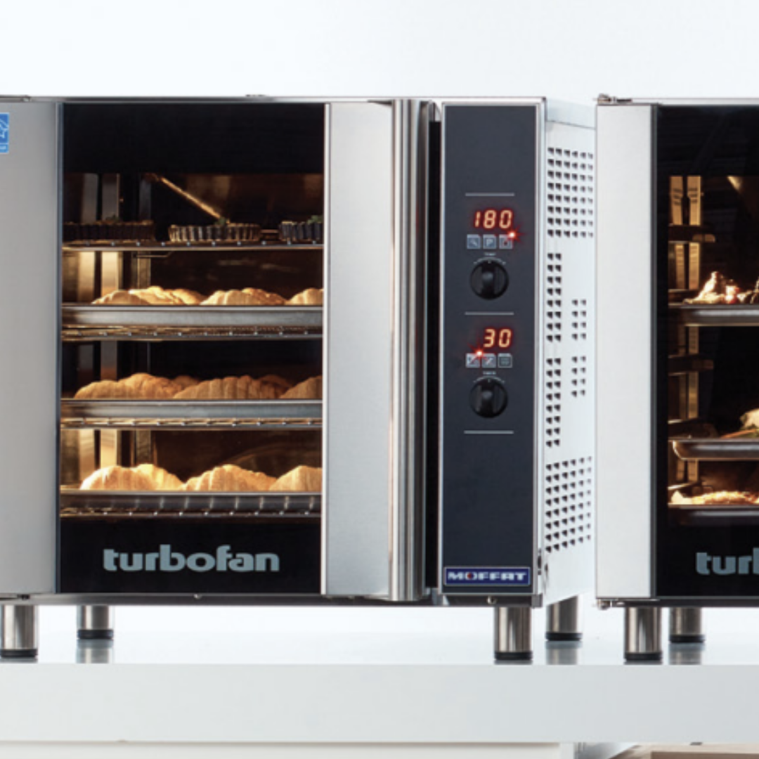 Turbofan convection oven with lights on and croissants baking inside 